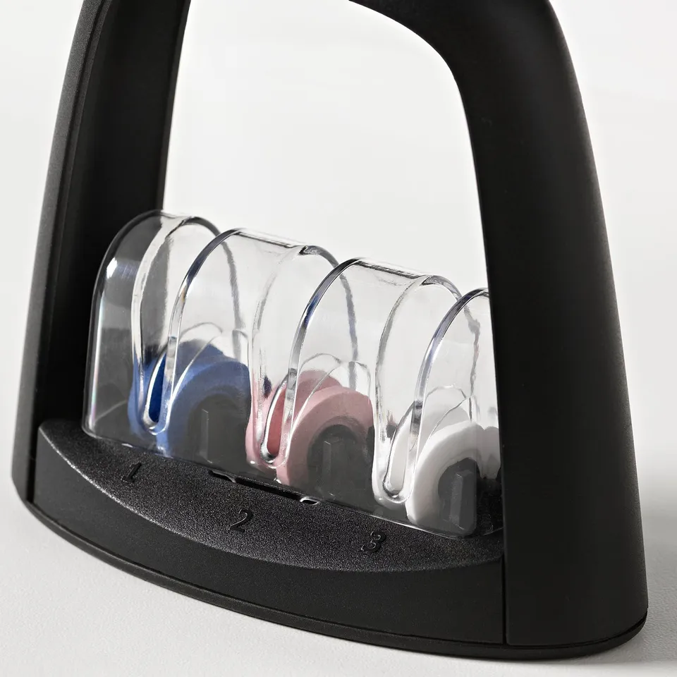 Black multi-stage knife sharpener with clear plastic covers, featuring three sharpening slots for various grit levels.