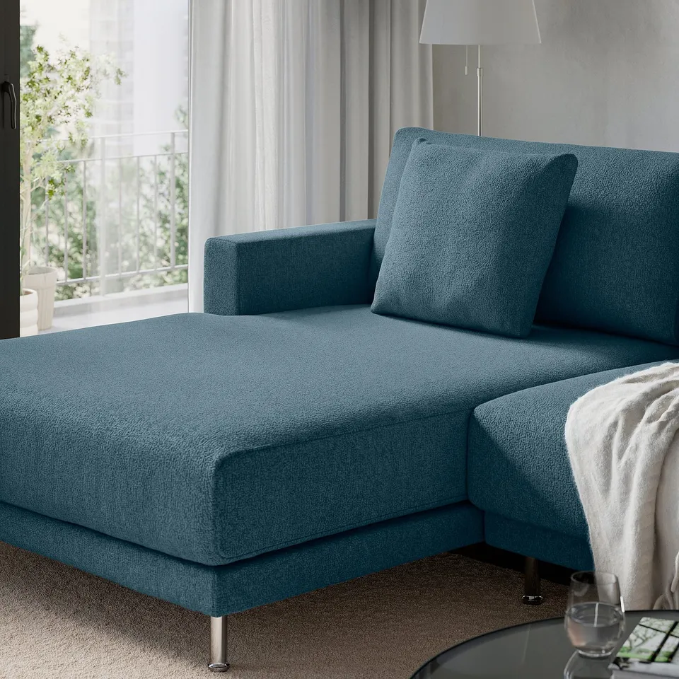 Turquoise sectional sofa with clean lines and large cushions near a window.