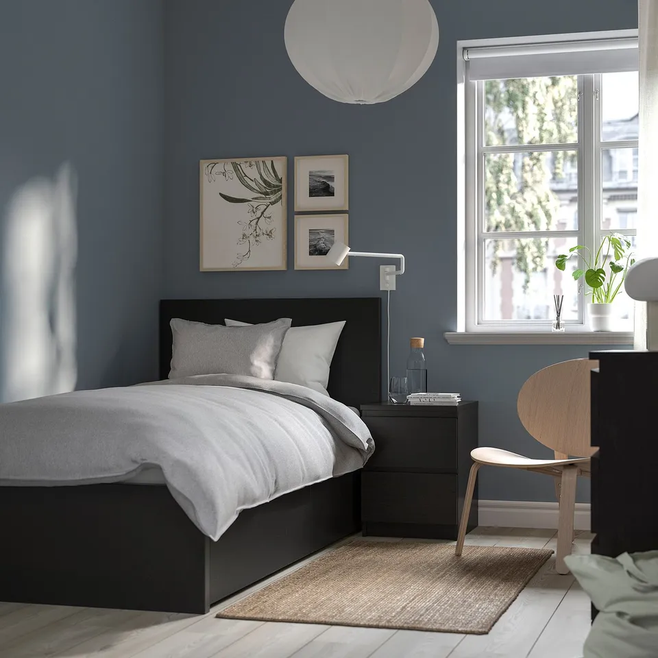 Modern bedroom with black MALM bed, dark blue wall, wooden nightstands, art, and window view.