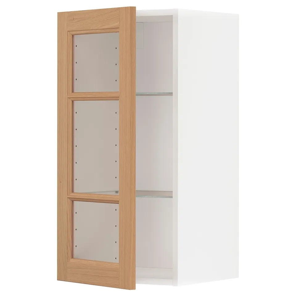 An ikea METOD kitchen cabinet with oak doors and glass shelves.