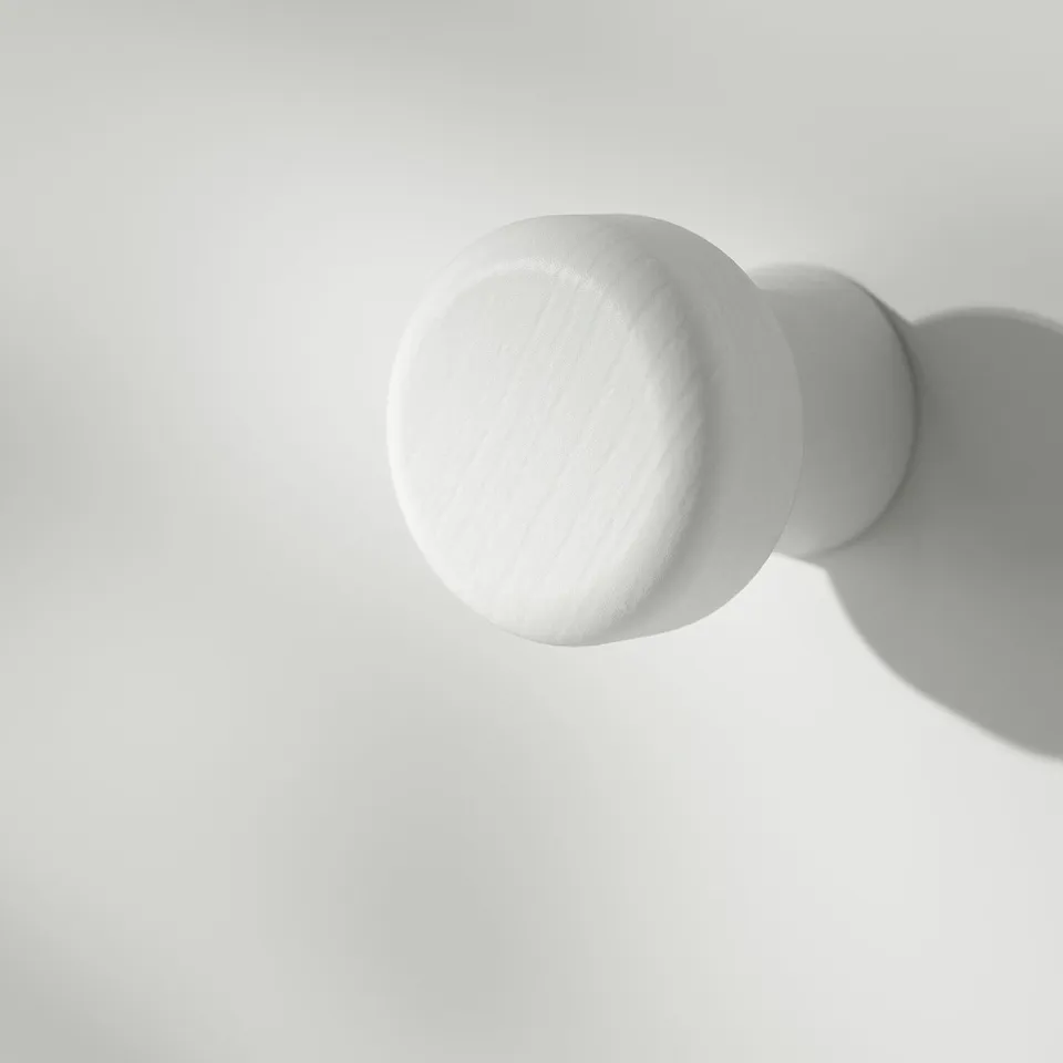 Spherical white object casting sharp shadow, pristine texture, clean aesthetic.