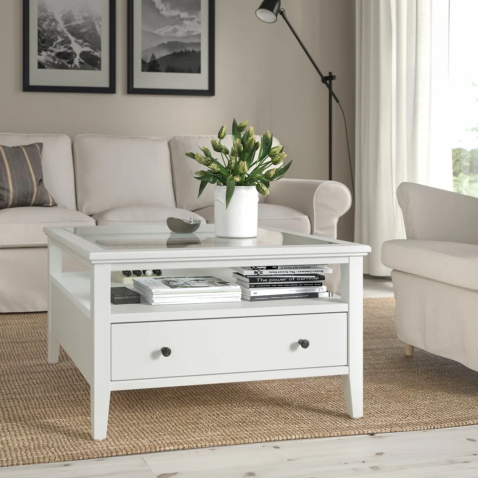 IDANÄS coffee table with glass top and drawer in living area.
