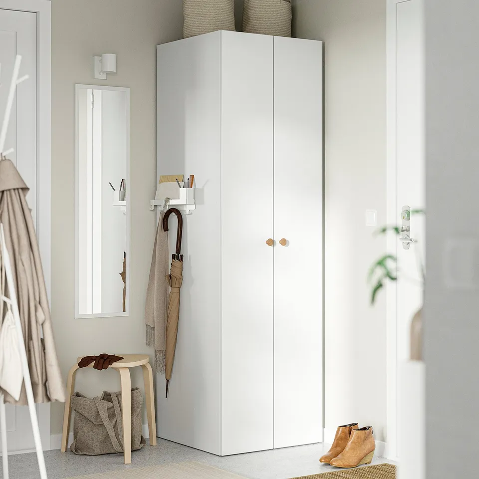 White IKEA wardrobe with 2 doors, mirror, & hooks with umbrella, scarf, coat. Small stool & boots. Beige accents.