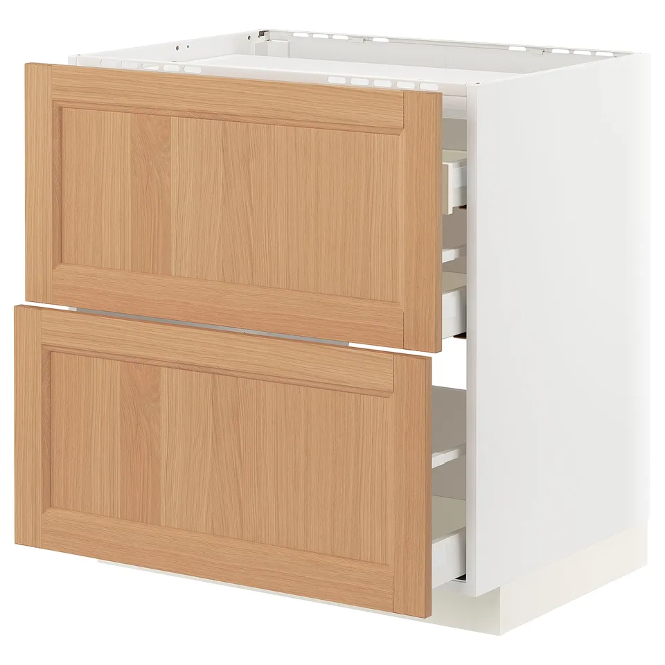 A METOD kitchen cabinet with oak drawers and a white base. It has a sleek, modern design with a light wood finish and several pull-out drawers.