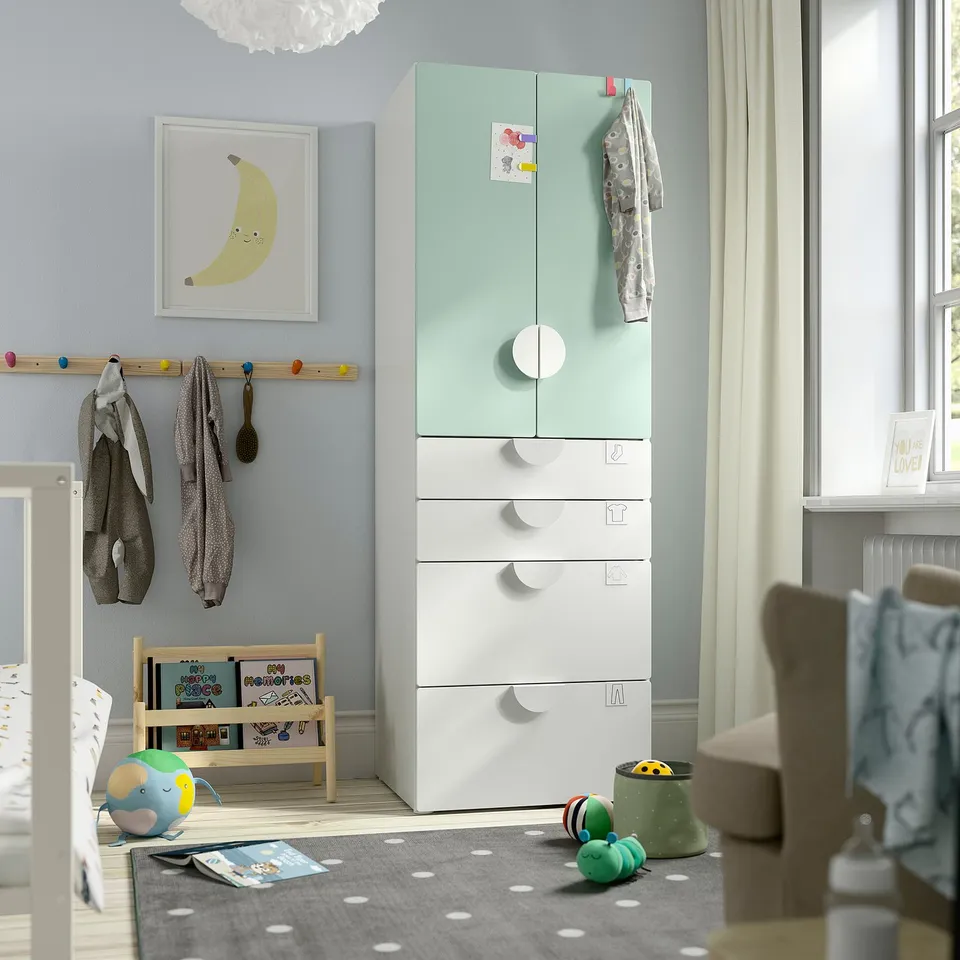 SMÅSTAD wardrobe in kids room, mint-green, white, tall with drawers and hanging space, soft toy, books, rug below.