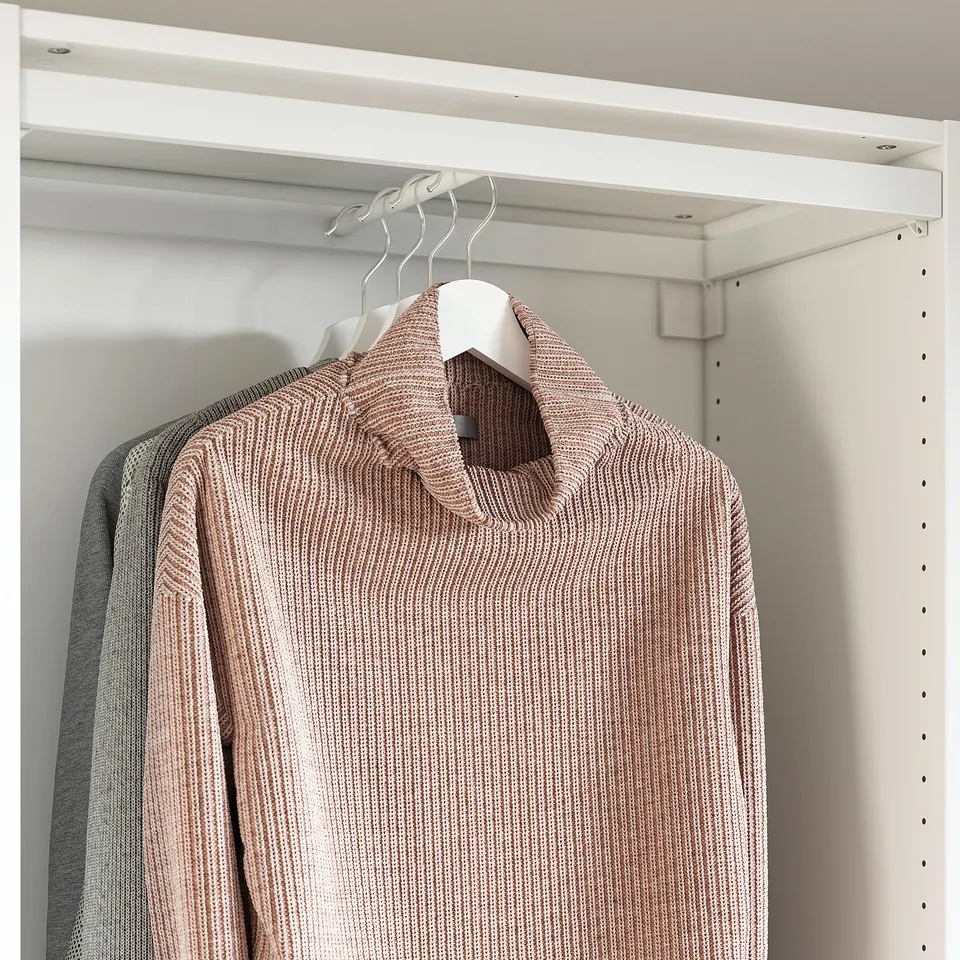 A modern closet with sliding doors, showcasing a brown sweater on a clothes hanger.