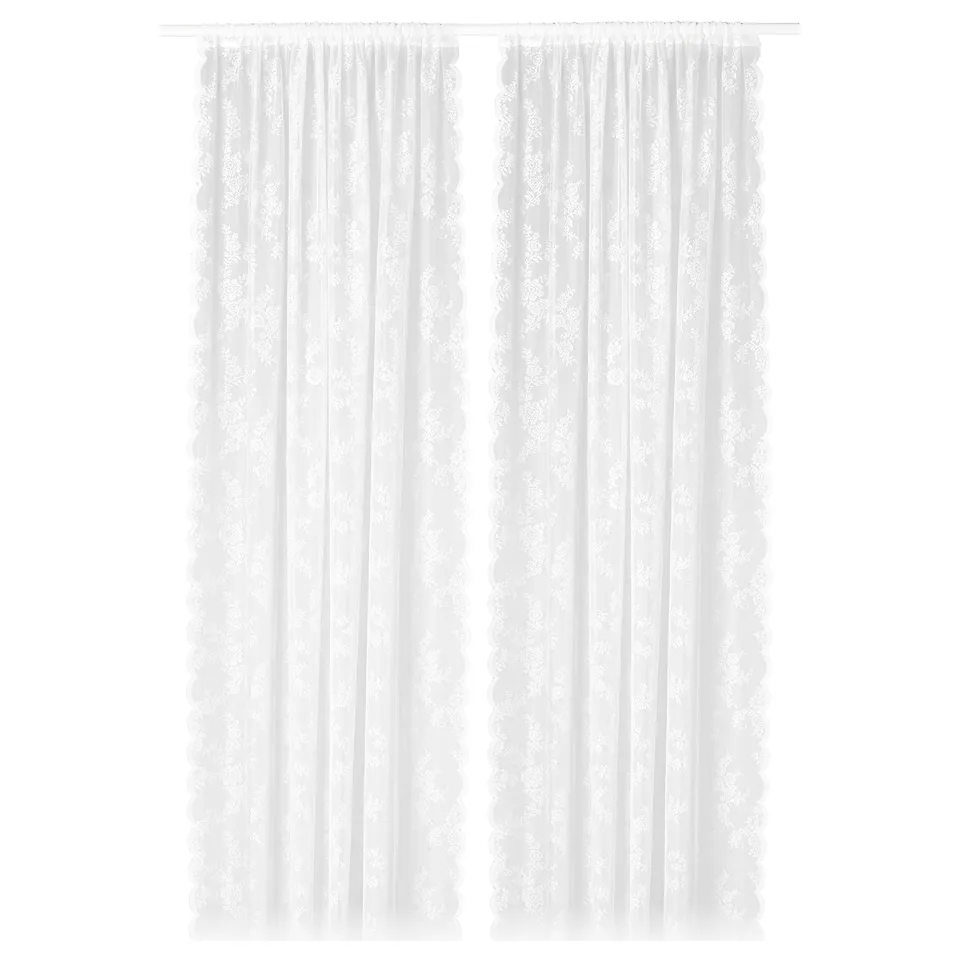 White lace-like curtain panels with floral pattern, sheer, hanging straight.