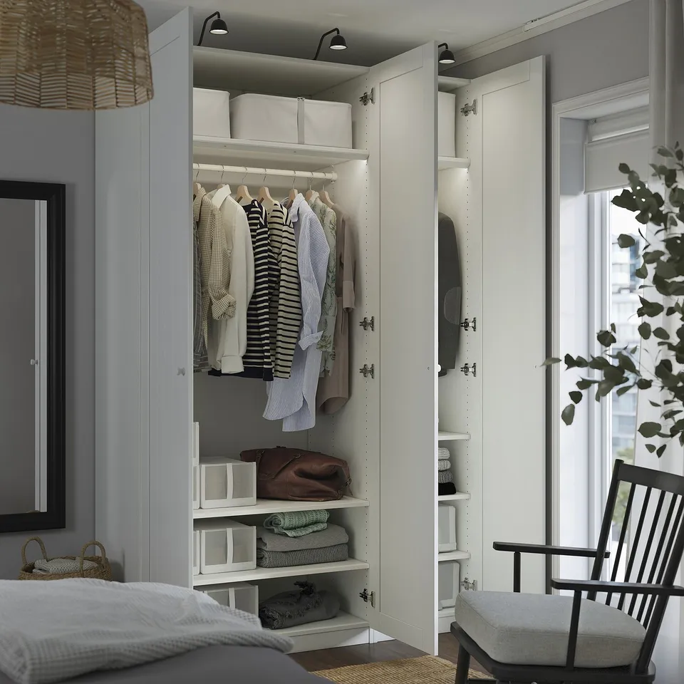 Open wardrobe displaying shirts on hangers, folded clothes, and storage boxes. Adjustable shelves and soft-close hinges.