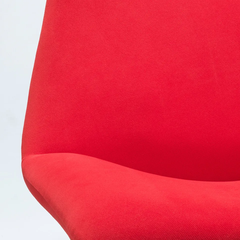 Bright red modern armchair, smooth fabric, clean lines, inviting.