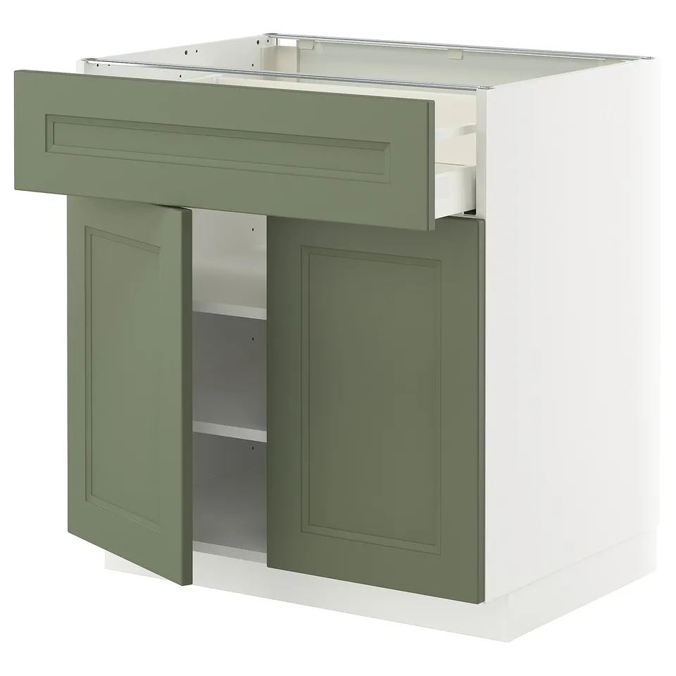 A green and white METOD kitchen cabinet with a draw and open door revealing shelves inside.