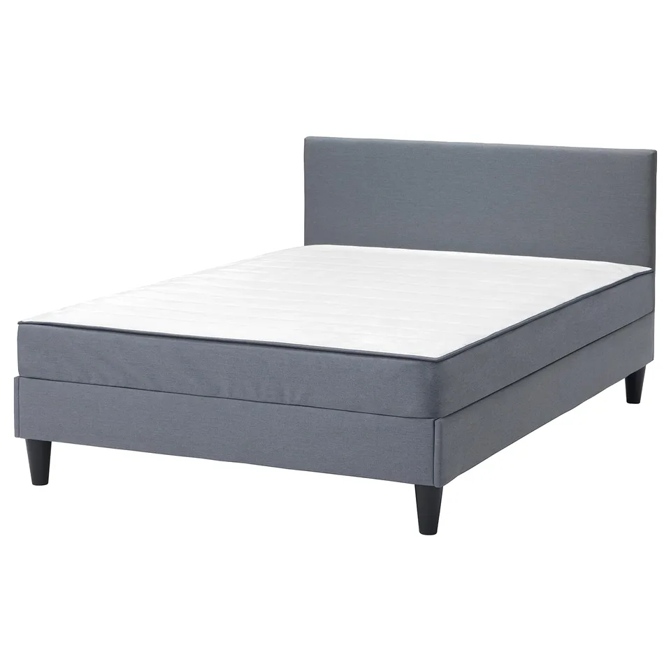 Grey upholstered bed with padded headboard, square legs, and white mattress. Modern and comfortable design.