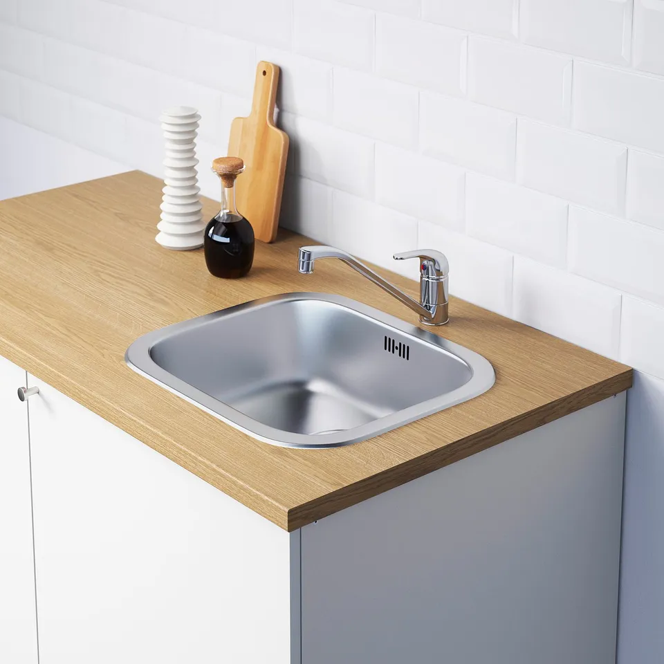 Kitchen sink with tap, wood counter and white tile backsplash.