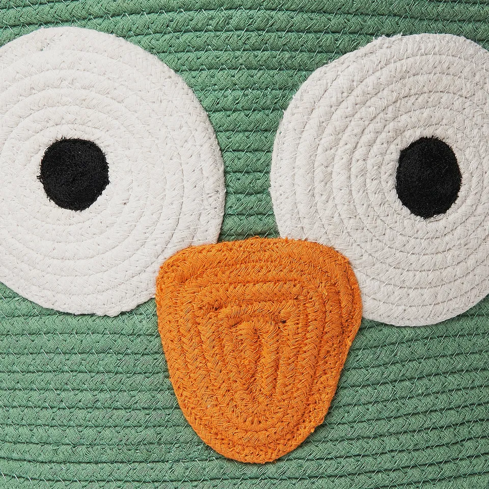 A handwoven owl-shaped storage bag made of soft, braided cotton, featuring large white eyes and a yellow-orange beak, perfect for childs room.