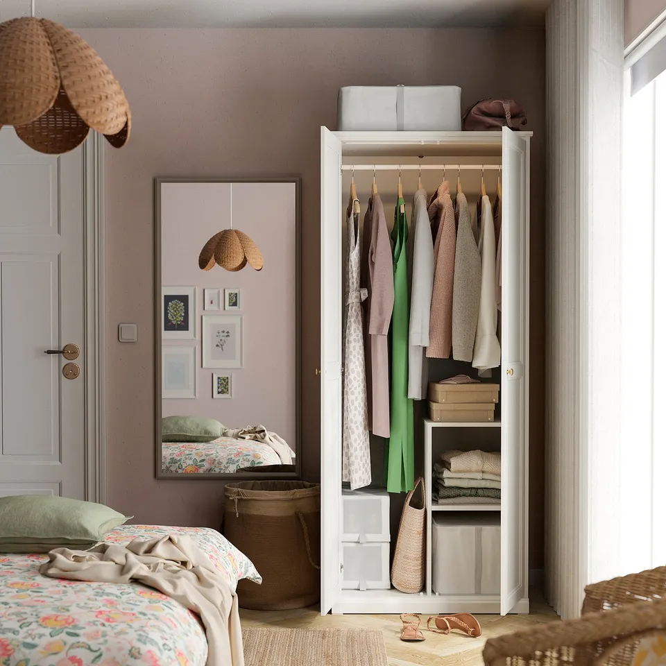 Bedroom with tall white wardrobe, mirror, and bed reflected.