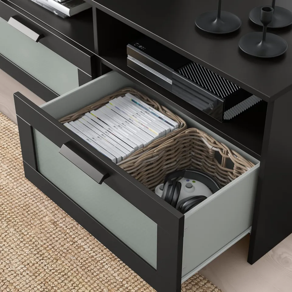 Image shows open tv bench with magazines and gaming accessories organised in drawers, featuring cable management.