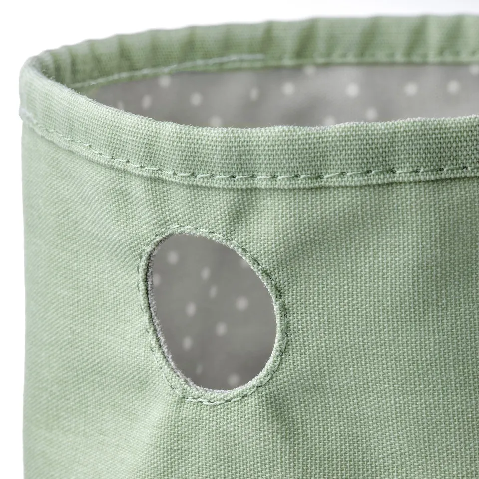 Green round storage bag with grey dotted lining.