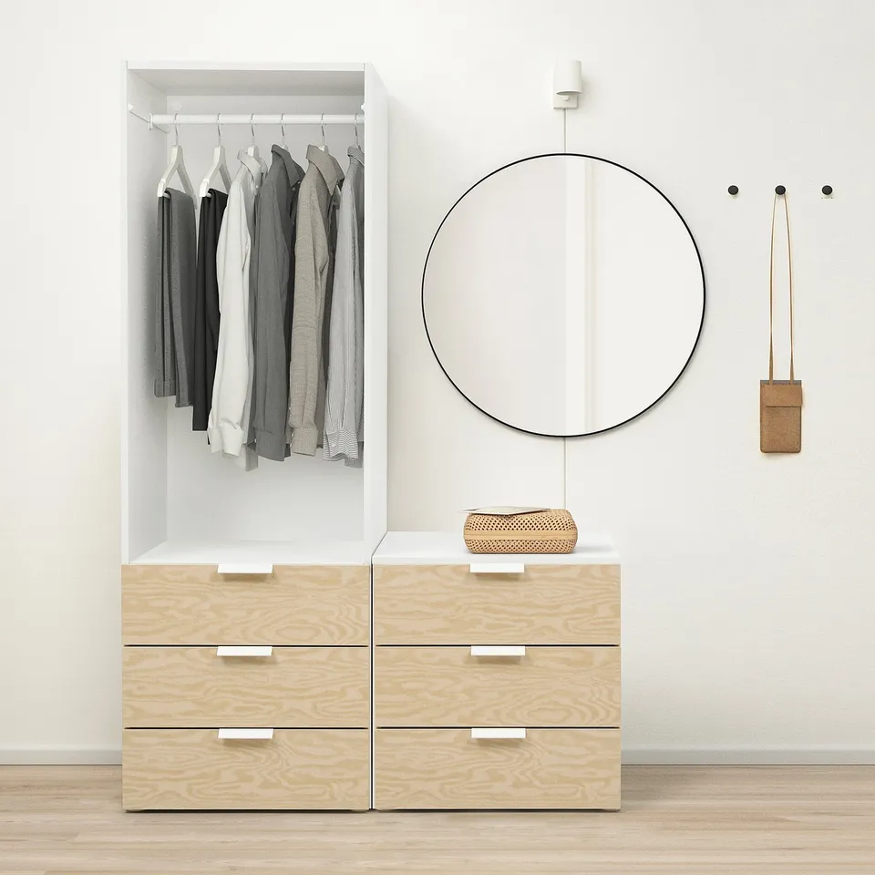 Modern closet with clothes, light wood drawers, round mirror. Adjustable, wall-mountable.