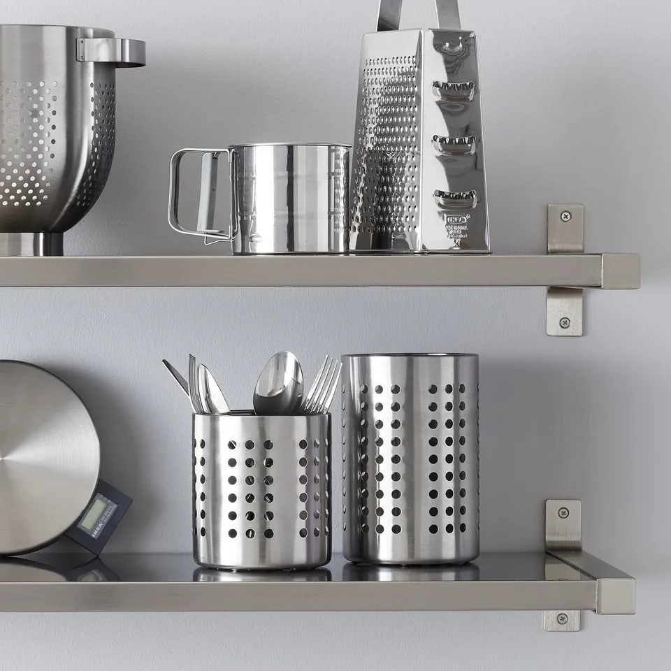 Stainless steel kitchen shelf with perforated utensil holders and grater.