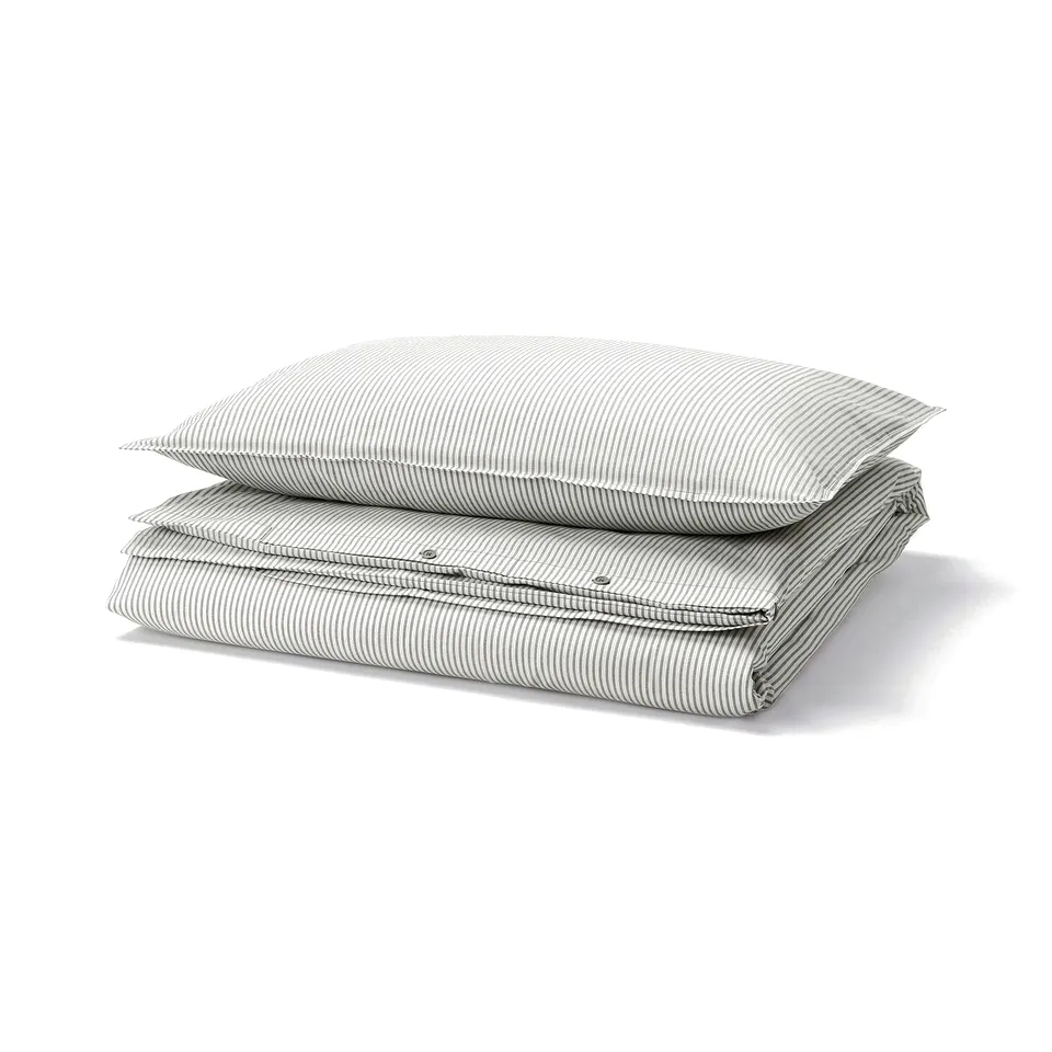 Stacked grey & white striped SOLFIBBLA duvet & pillow covers, made of recycled cotton.