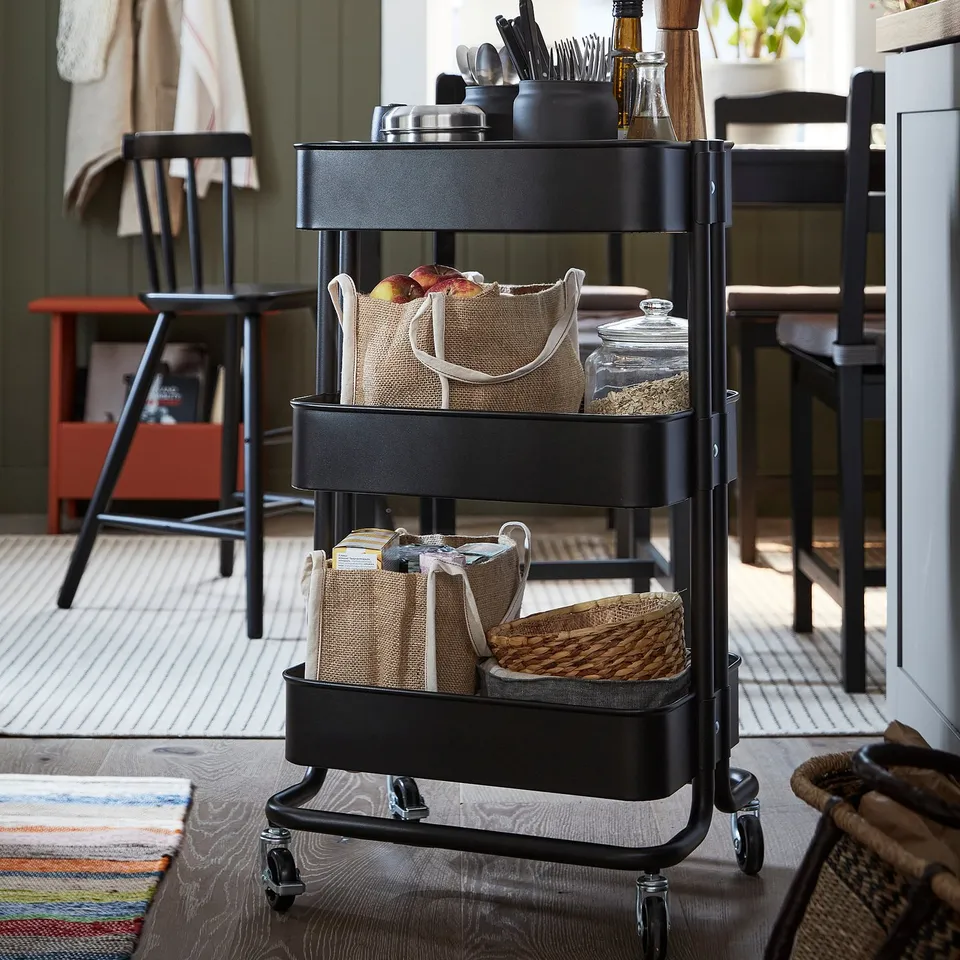 Three-tier storage cart with kitchen essentials.