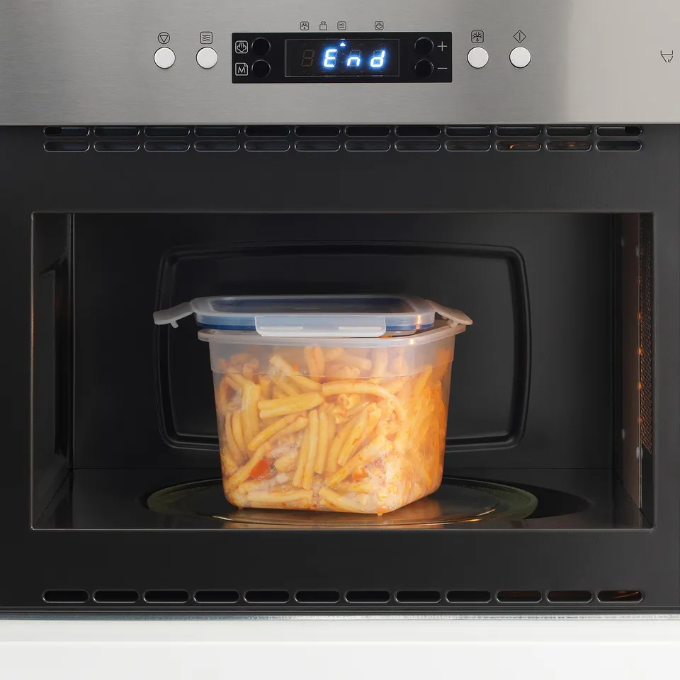 A plastic container with a locking lid in a microwave, heating food.