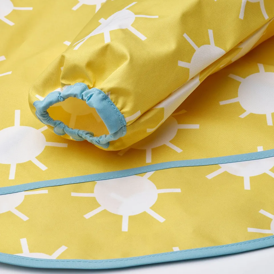 Yellow bib with white sun prints, light blue trim, and elastic, showcasing quality fabric and design.