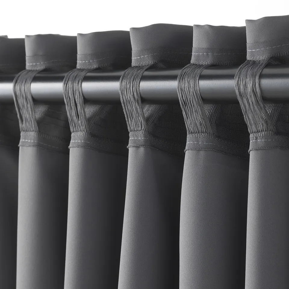 Blackout curtains hang with loops, blocking light and providing privacy.