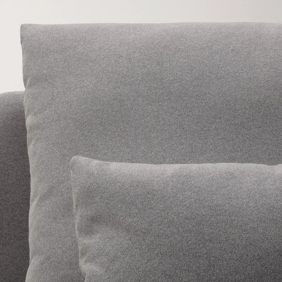 Closeup of grey upholstered sofa, showcasing soft, textured fabric and clean design.