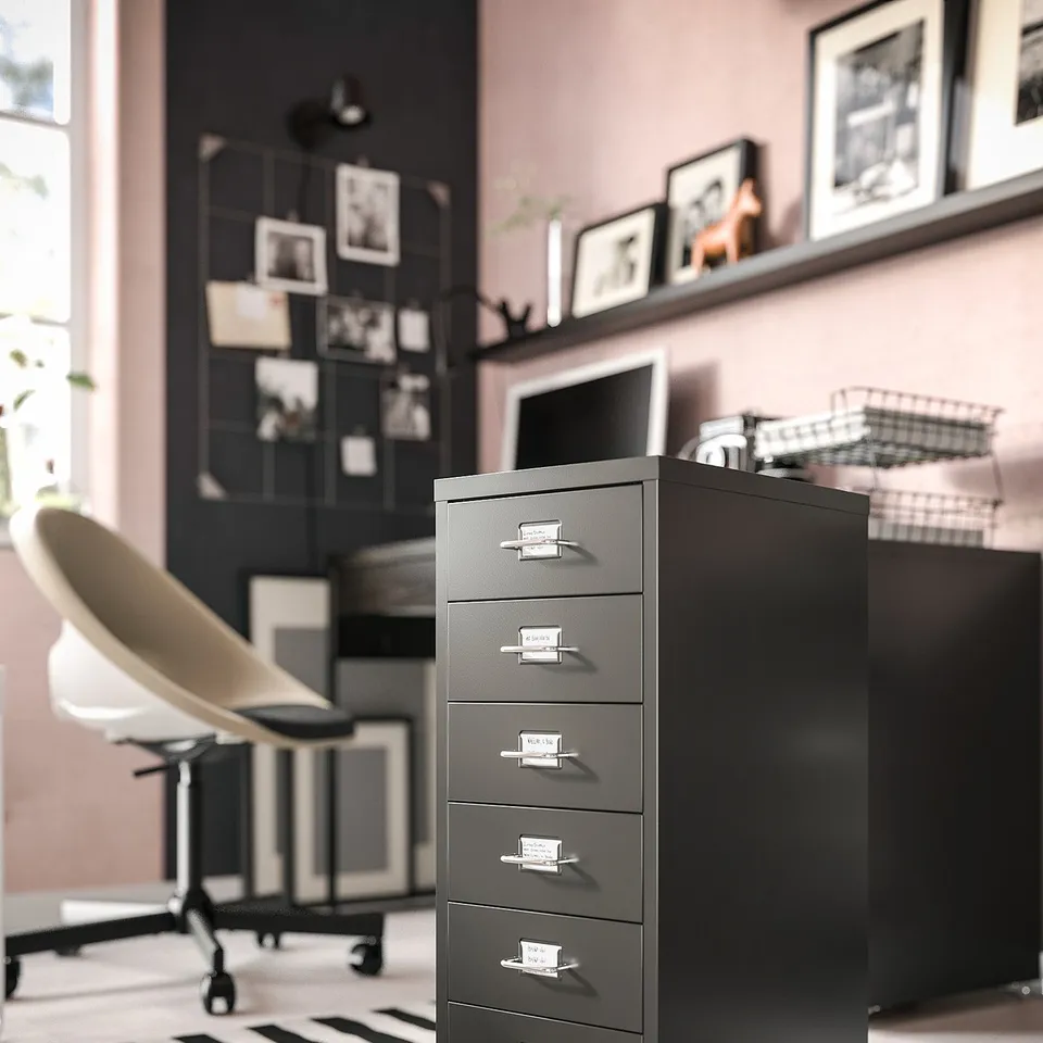Modern home office with grey filing cabinet, ergonomic chair, and black/white rug.