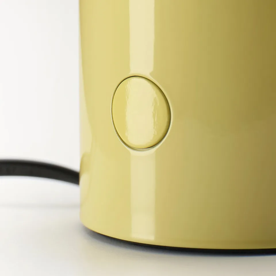 A yellow table lamp with a sleek design and a small button on the side for control.