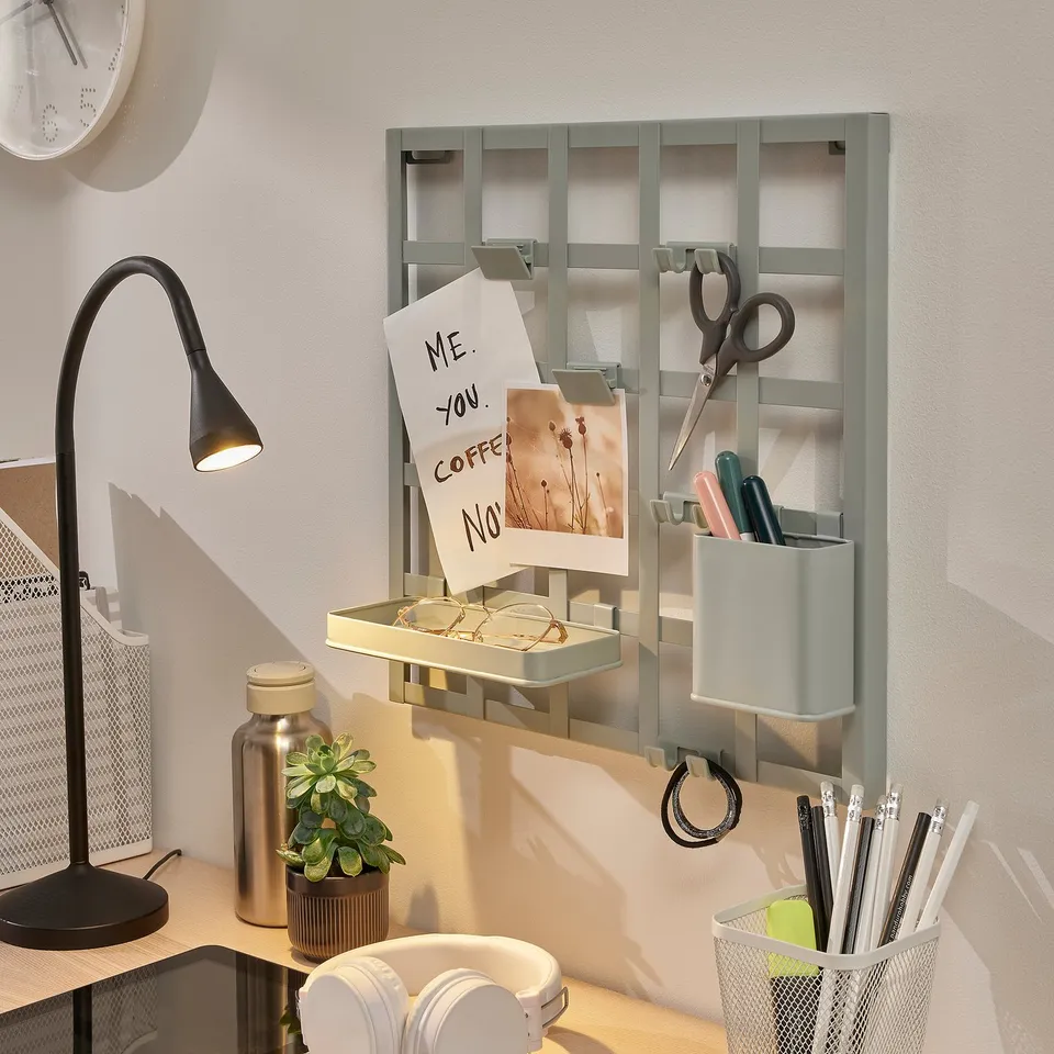 Wall-mounted office organiser with note holder, pen container, and hooks. Includes a shelf and clips for storage.