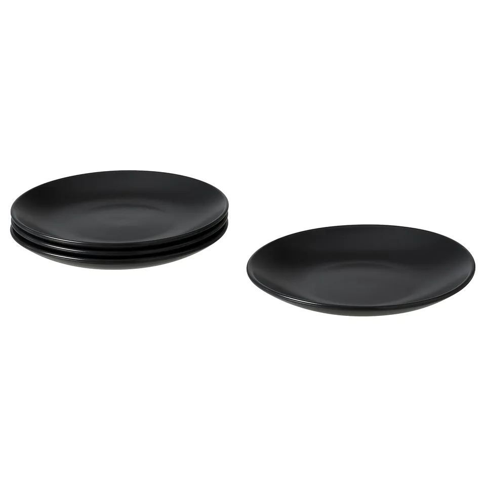 Image shows four black FÄRGKLAR ceramic plates, three stacked and one single, with a simple, round design.