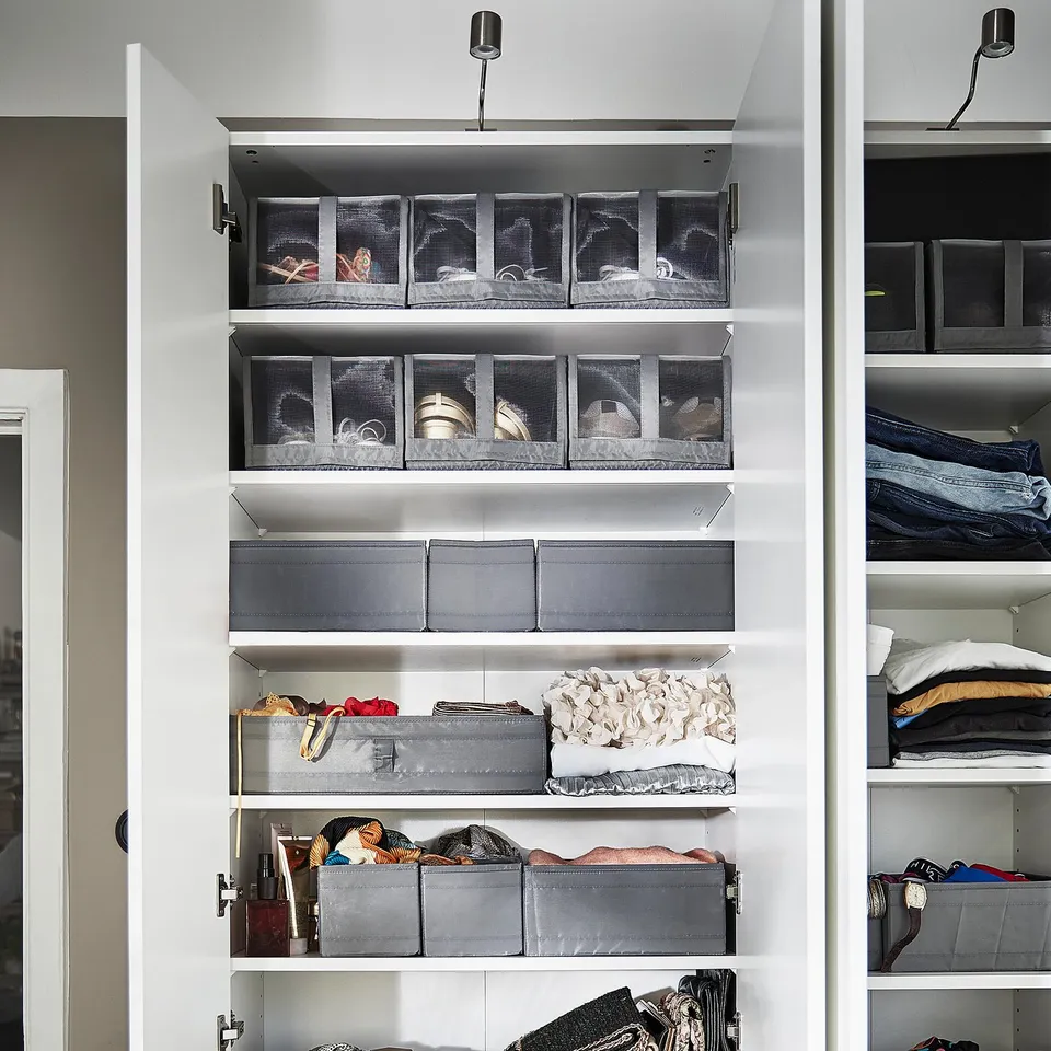 Image shows a white closet with SKUBB shoe boxes in grey on shelves, keeping items organised and visible.