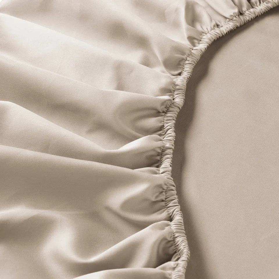 Smooth bedsheet detail: elegant sheen, elastic edges, luxury texture