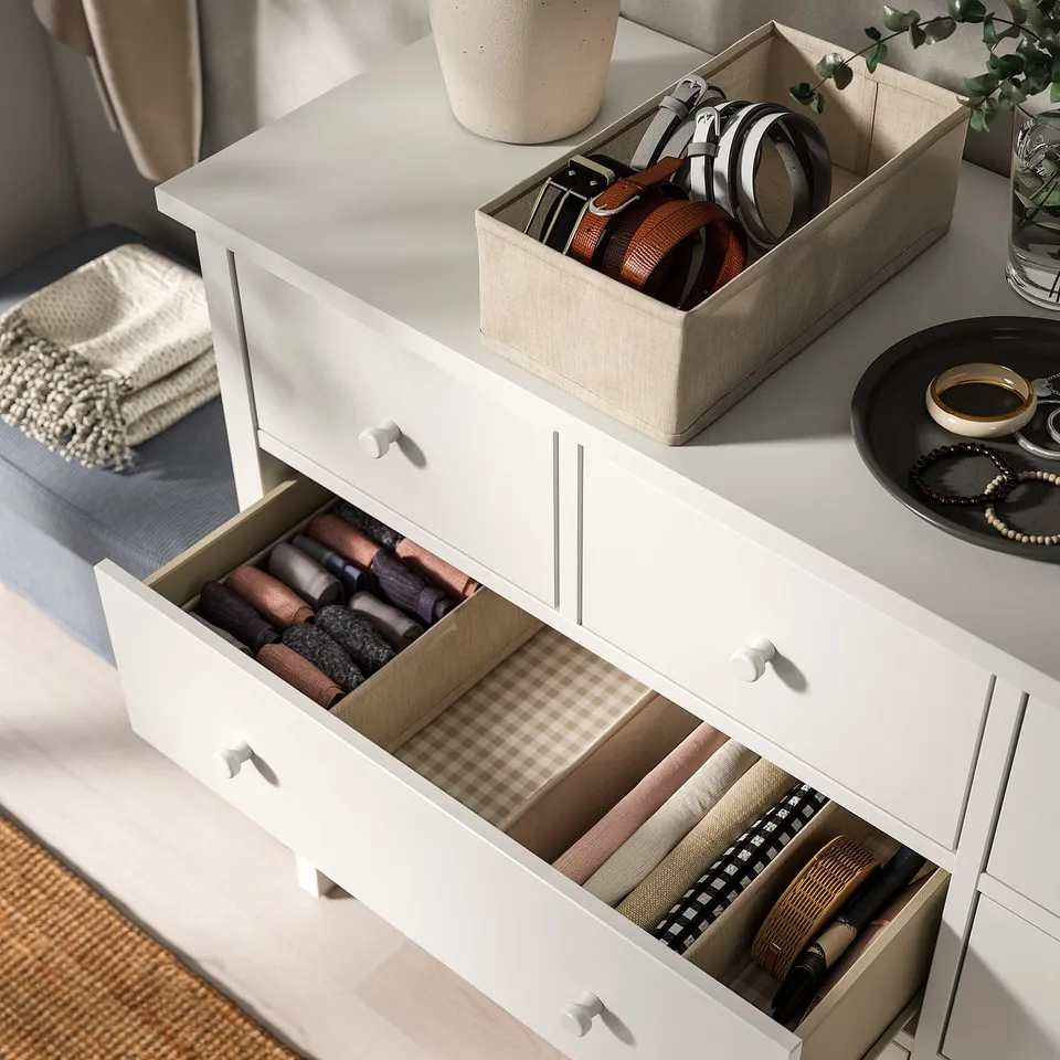 White chest with open drawers, showcasing organised socks and accessories, demonstrating functional storage and organisation.