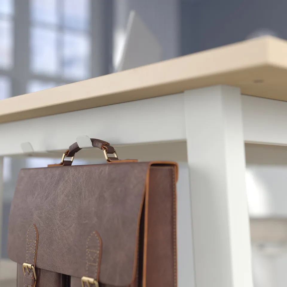 Brown leather briefcase hangs on reception desks metal hook. Desk has footrests for standing work.