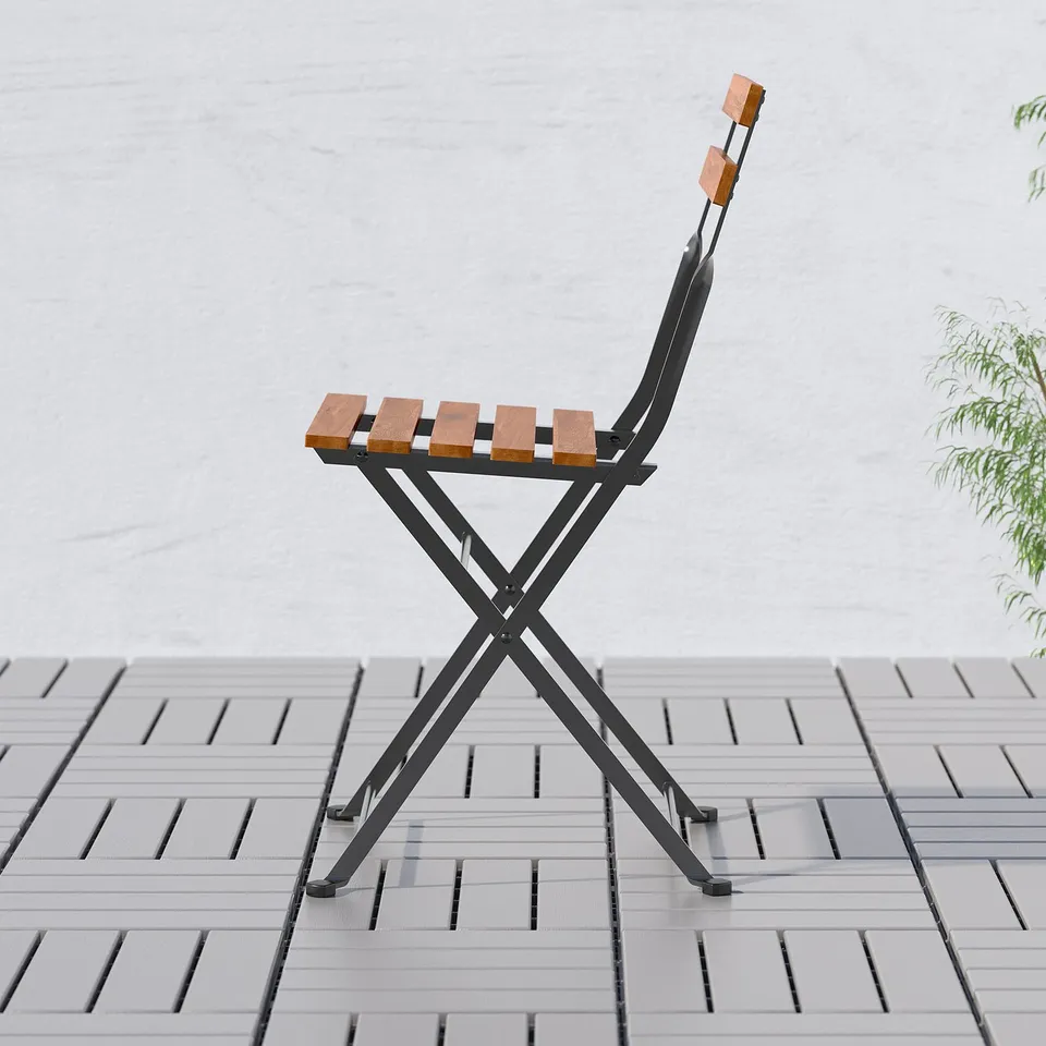 Folding chair with wooden seat and back, ideal for small spaces.