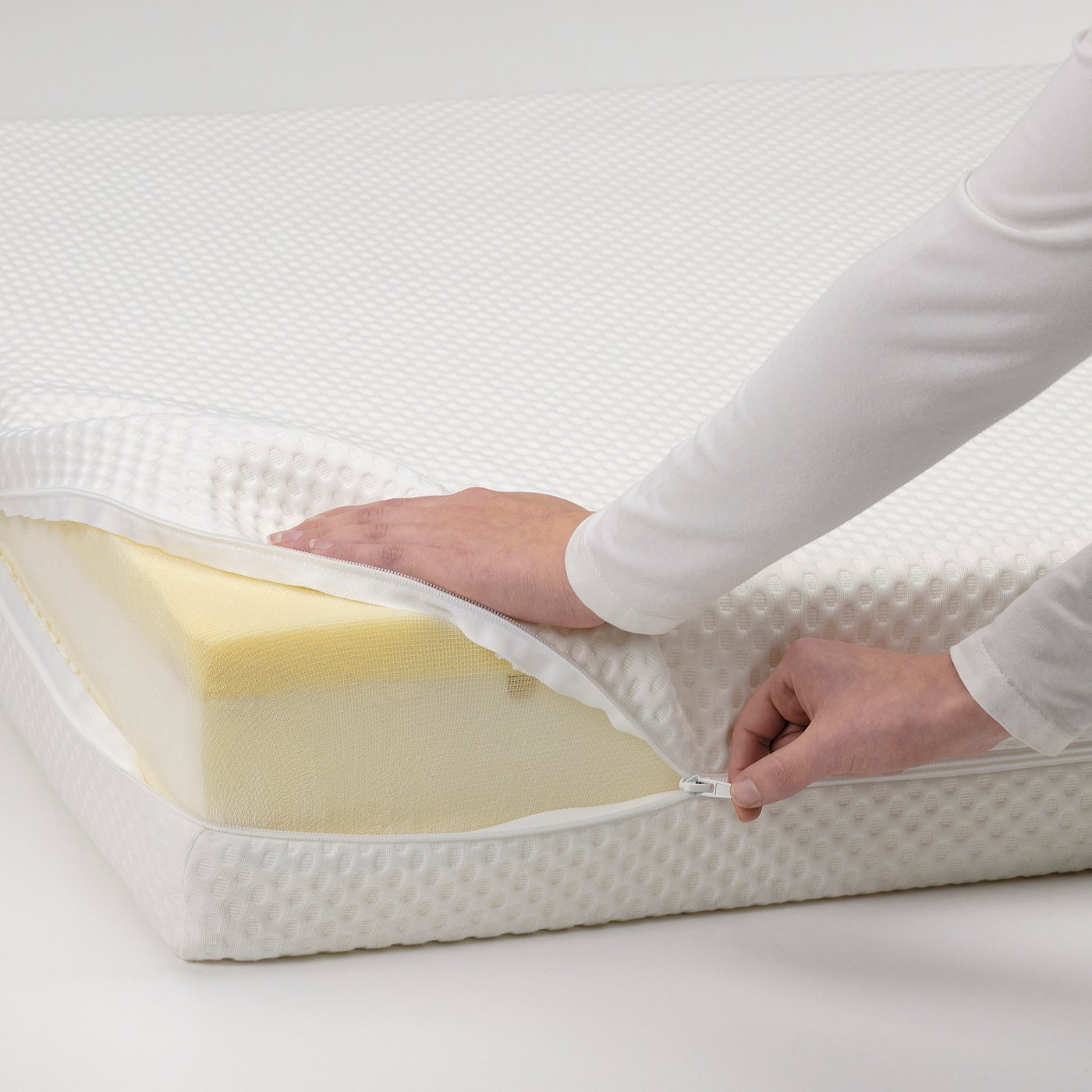 Person closing zip on a memory foam mattress.