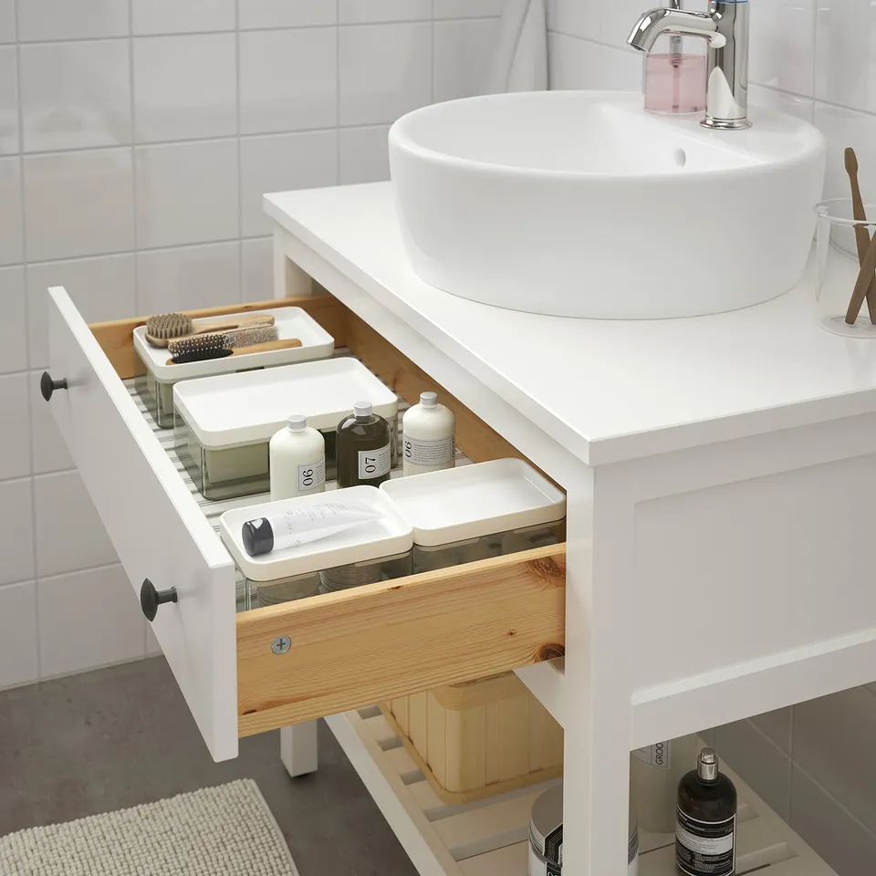 White bathroom vanity with drawer open, showing organised toiletries and grooming items. Soft-close mechanism visible.