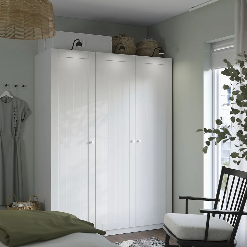 White wardrobe, black chair, green bed, wicker basket, decor.