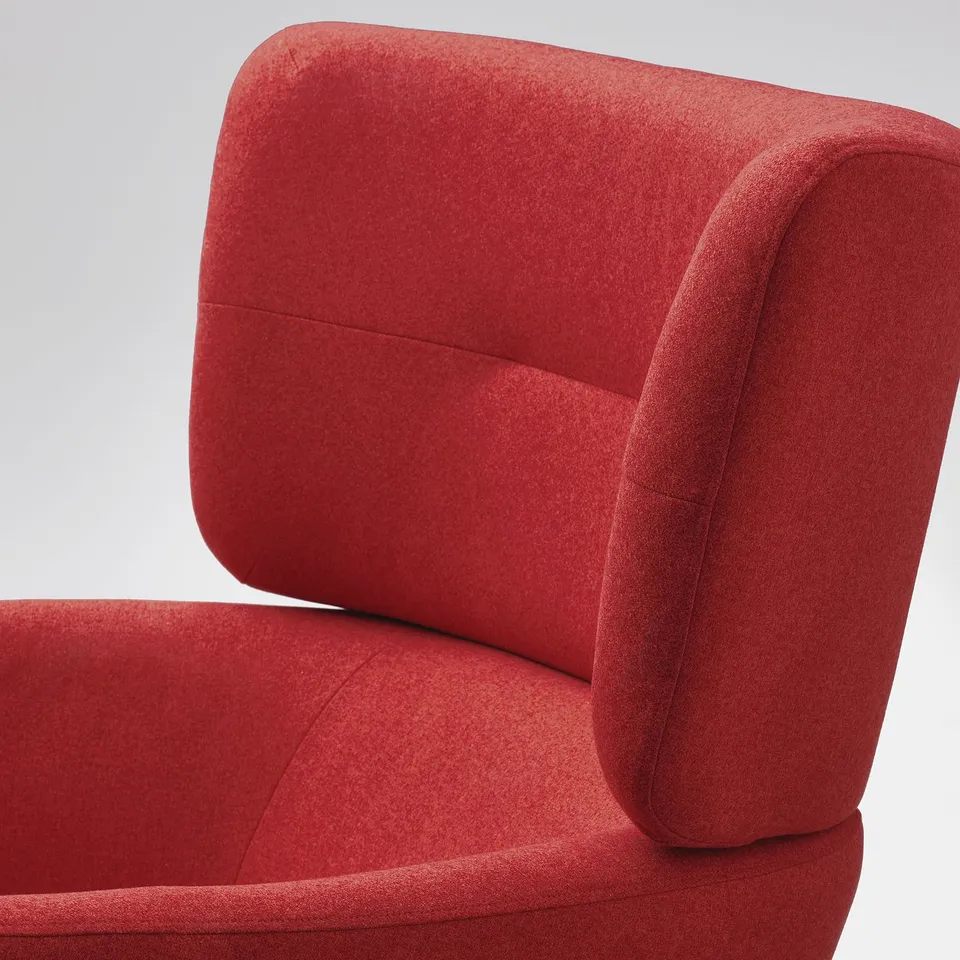 Bright red upholstered chair with high back, curved armrests, showing soft fabric quality.