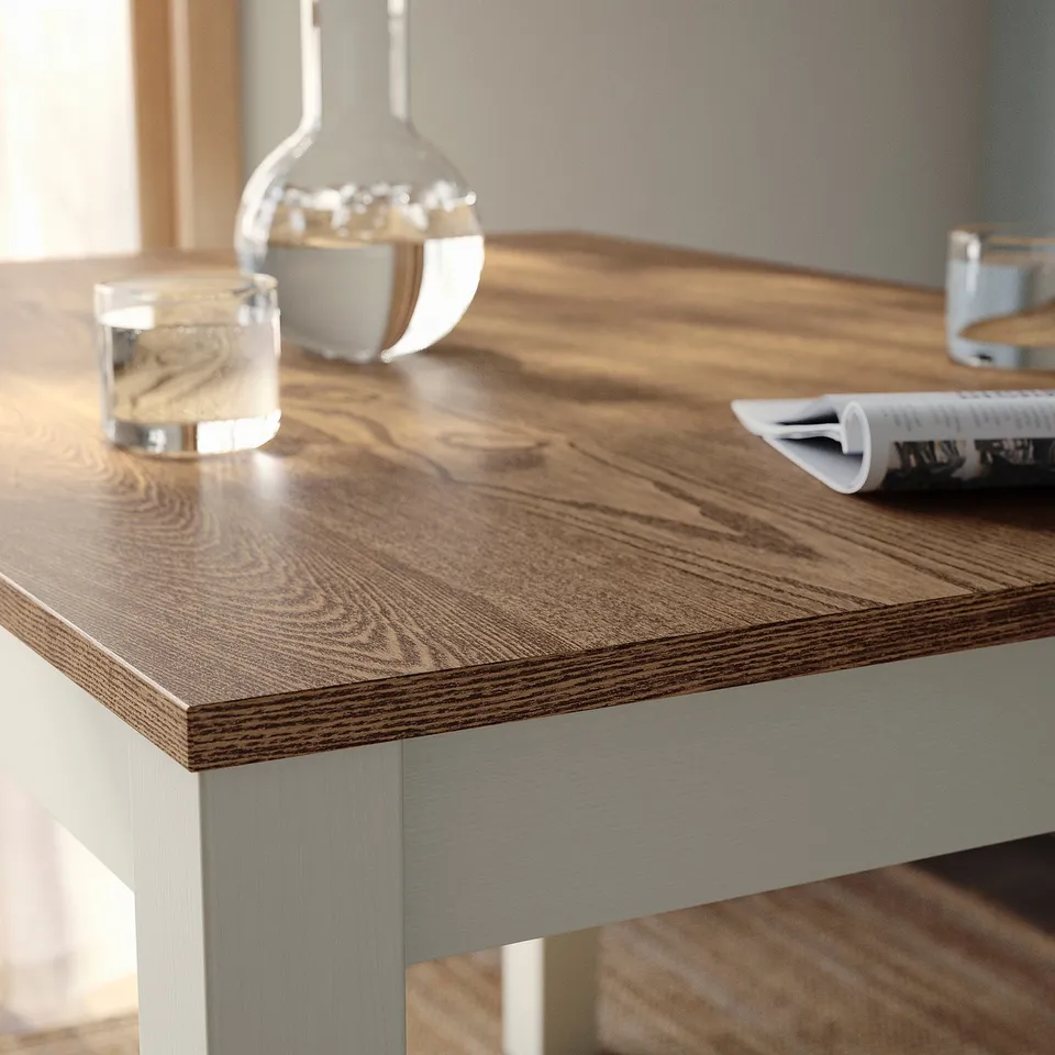 Close-up of ÅLHULT tables smooth, polished wooden surface with decorative items.