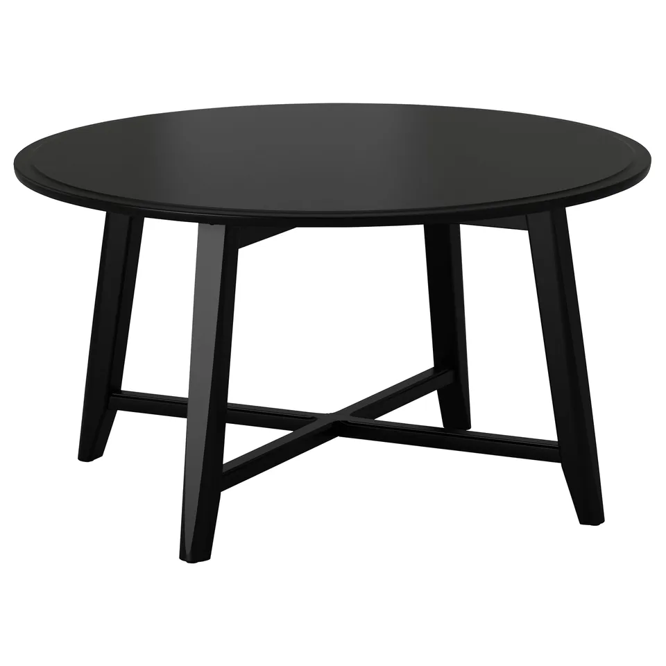 Black round coffee table, sleek design, four angled legs, solid wood.