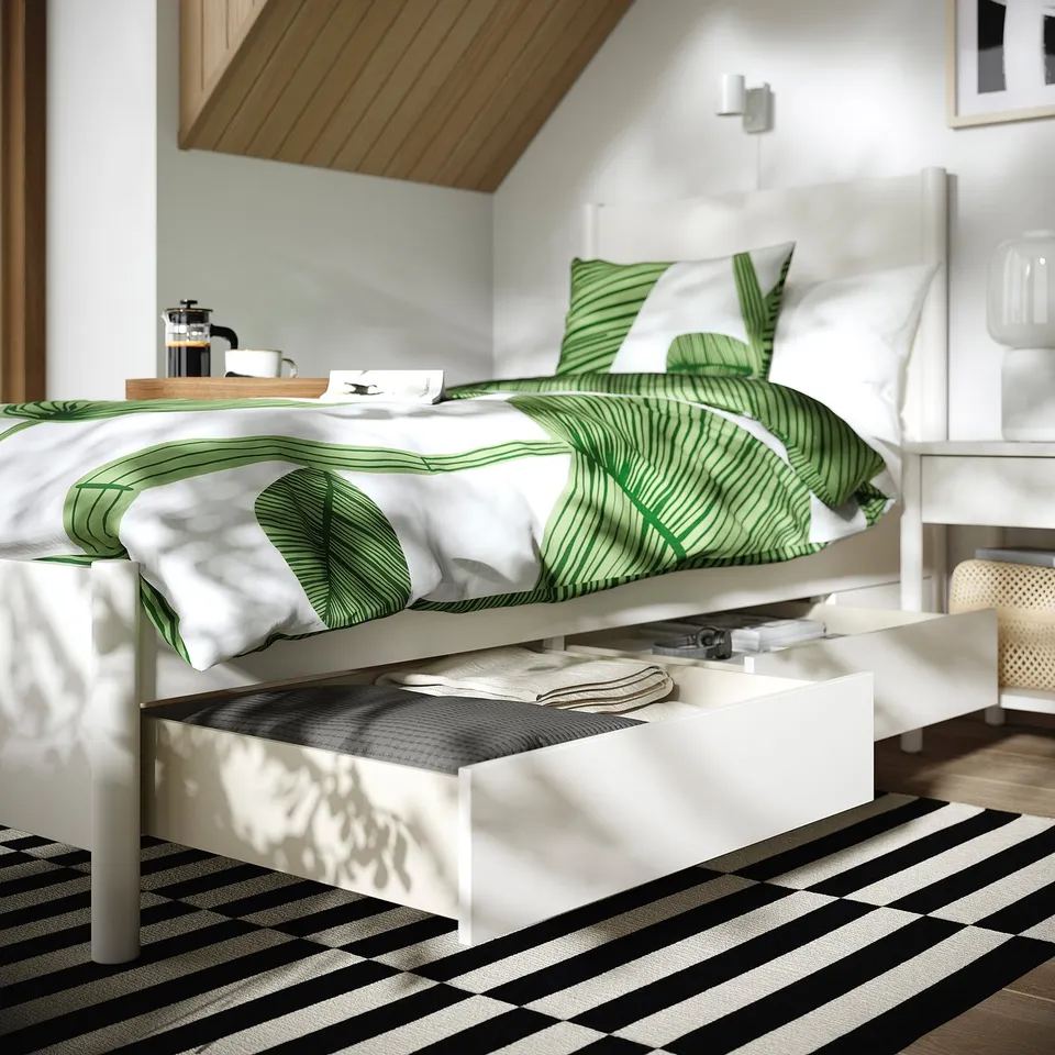 Modern bed with drawers, off-white. Green leaf bedding, coffee tray, open drawer under soft close.