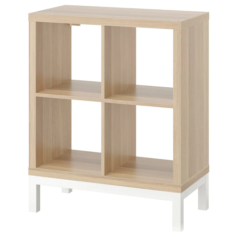 KALLAX light wood bookshelf, white legs, four cubes, simple design.