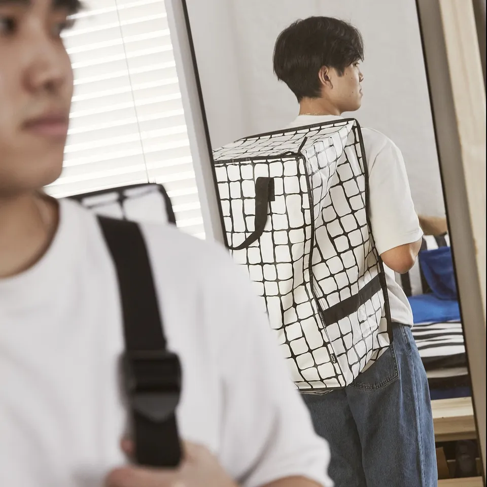 Two people in casual clothes; one wears a unique patterned backpack