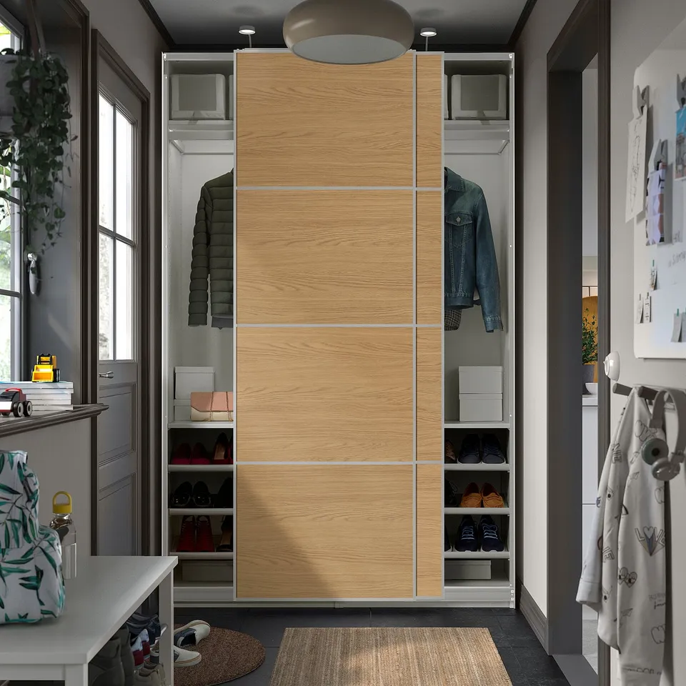 Modern wardrobe with sliding oak doors, housing clothes and shoes in an organised space.