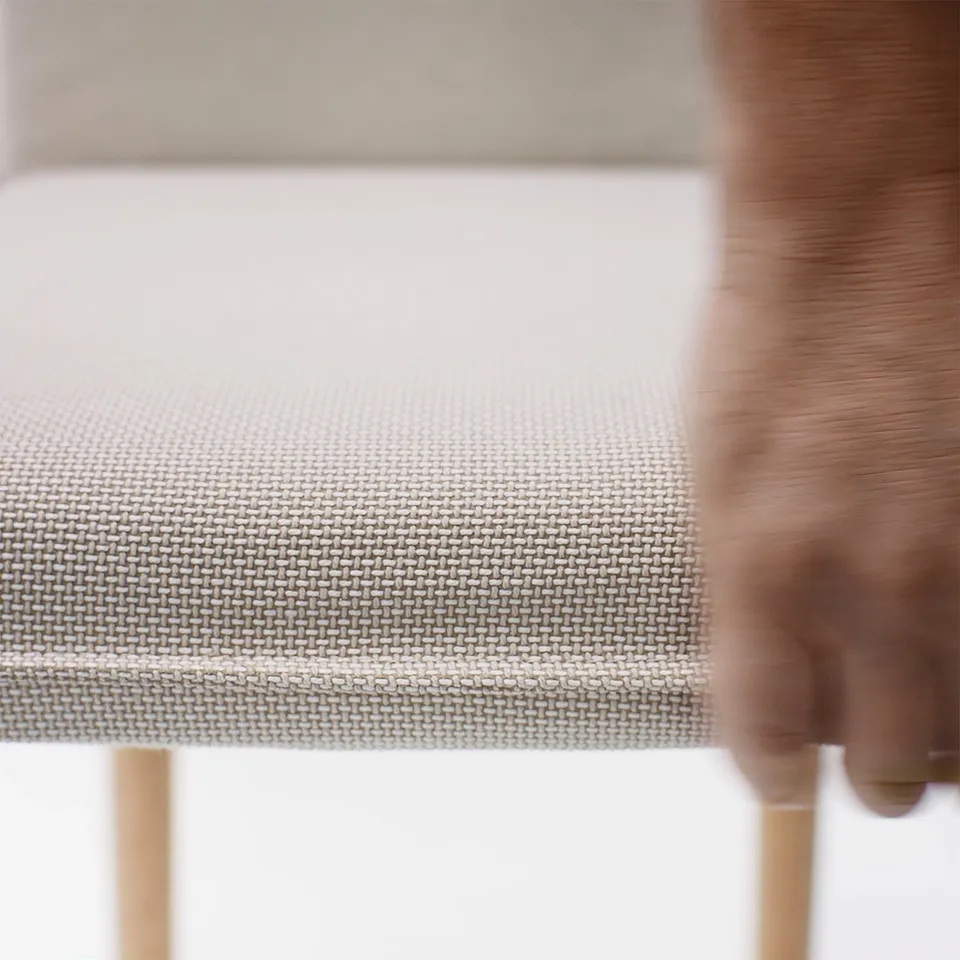 Close-up of woven fabric chair, showcasing intricate weave and plush texture, indicating high-quality comfort and durability.