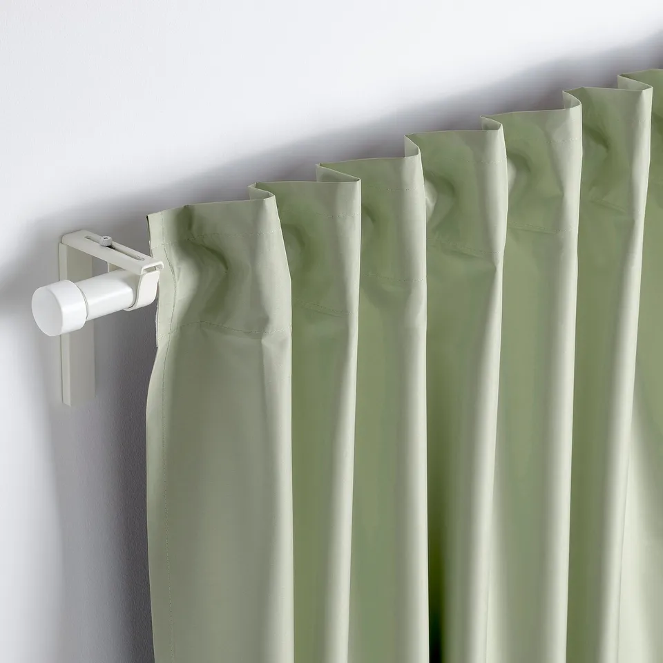 Green block-out curtain with hanging rod. Light-proof, adjustable length. Shows rod pocket detail.