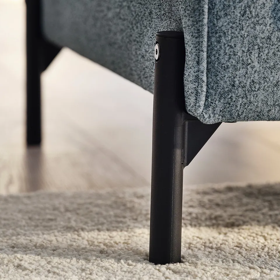 Close-up of sofa leg, sleek design, sturdy black metal, good quality.